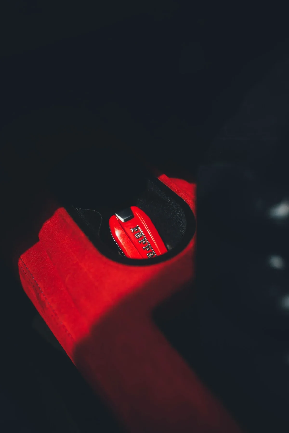 Chave de um automóvel pousada num suporte vermelho